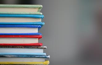 Photo of a stack of colourful books.
