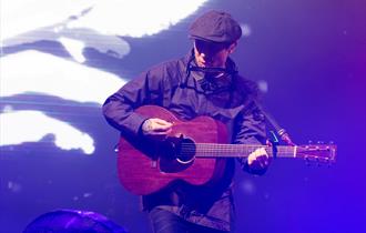 Gerry Cinnamon playing guitar and singing.