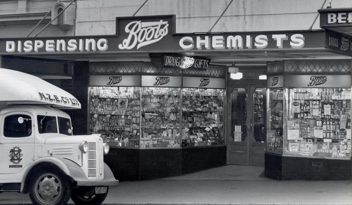 Black and white photo of an old Boots store front.