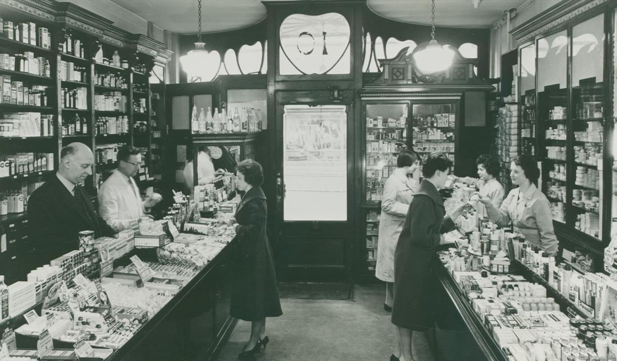Old blakc and white photo of the inside of a store.