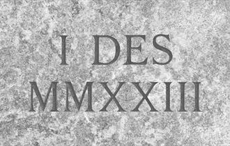 Graphic of I DES MMXXIII as if it were engraved on a marble stone