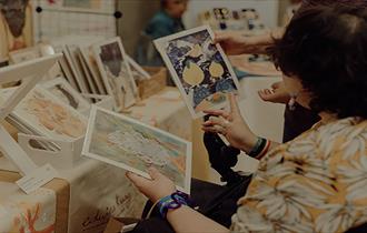 Photo of customers browsing art prints at the craft fair