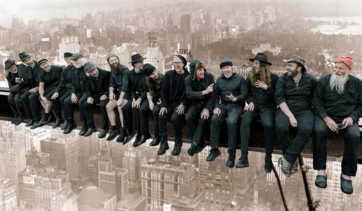 Graphic of The Spooky Men's Chorale showing them recreating the famous image of men sitting along a steel girder in the air when builidng the Empire S
