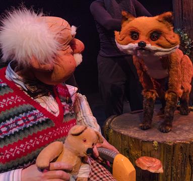 Photo of the stage show including a puppet of a man and a fox.