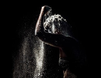 Black and white image of woman covering herself with crumbs