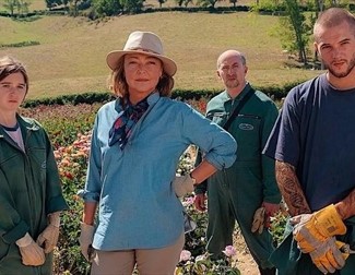 four people standing in a garden