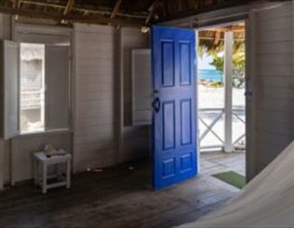 photo of house door opening onto a beach