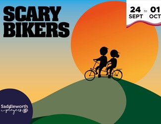 Silhouette of two bikers going over a hill
