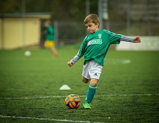 Child kicking football