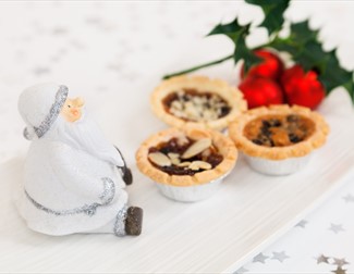 mince pies on a plate with holly and Santa Claus