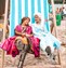 Giant deck chair with two women dressed as disney princesses sat in it