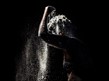Black and white image of woman covering herself with crumbs