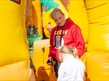 Jk Events crew staff member looking down at a child going into an inflatable