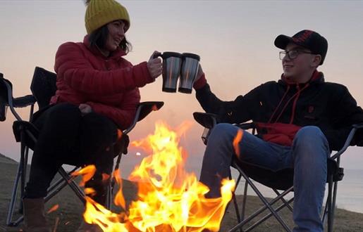 Heb360 Tours couple sitting at camp fire