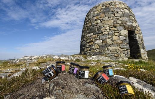 The Hebridean Mustard Company selection of mustard jars on rocks with cairn in the background