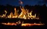 A blazing log in the fire pit at Mangersta Croft Holidays at dusk.