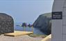 Dramatic cliffs and blue sea with two stylish pods in the foreground