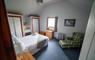 Am Bliochan self catering cottage north uist - double bedroom with chair and footstool.