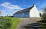 Am Bliochan self catering cottage north uist - exterior view from driveway with parking area.