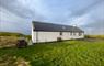 Am Bliochan self catering cottage north uist - exterior view with bench and parking area.