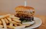 A classic hamburger and fries on a white plate.