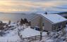 Dalhanna house in winter with snow and view of sea