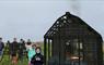 Group of children next to virtual hut with fire burning inside