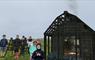 Group of children next to virtual hut with fire burning inside
