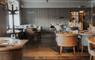 Rustic dining area with wooden tables and chairs in a restaurant.