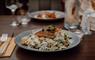 Plate of Scottish salmon risotto with a glass of wine on the table at Cleaver restaurant in Stornoway.