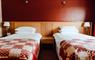 Twin beds at the Cabarfeidh Hotel in Stornoway with a red feature wall, and red check bed throws.