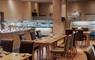 Spacious restaurant with carvery filled with numerous tables and chairs.