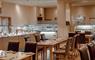Spacious restaurant with carvery filled with numerous tables and chairs.