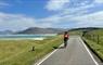 Cyclist passing beach in Harris