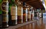 An array of single malt whisky bottles on a wooden sideboard