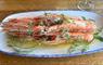 Hebridean langoustines on a white plate, sitting on a wooden table.