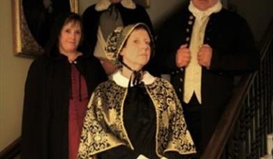 Costumed tour guides standing on Peterborough Museum staircase