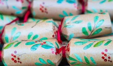 A close up image of holly printed Christmas crackers. 