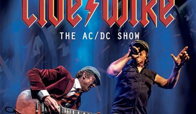 Image of Live/Wire performing on a blue background. Text reads: Live/Wire the AC/DC show.