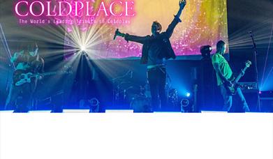 Coldpeace playing on stage with the word 'Coldpeace' in pink lettering