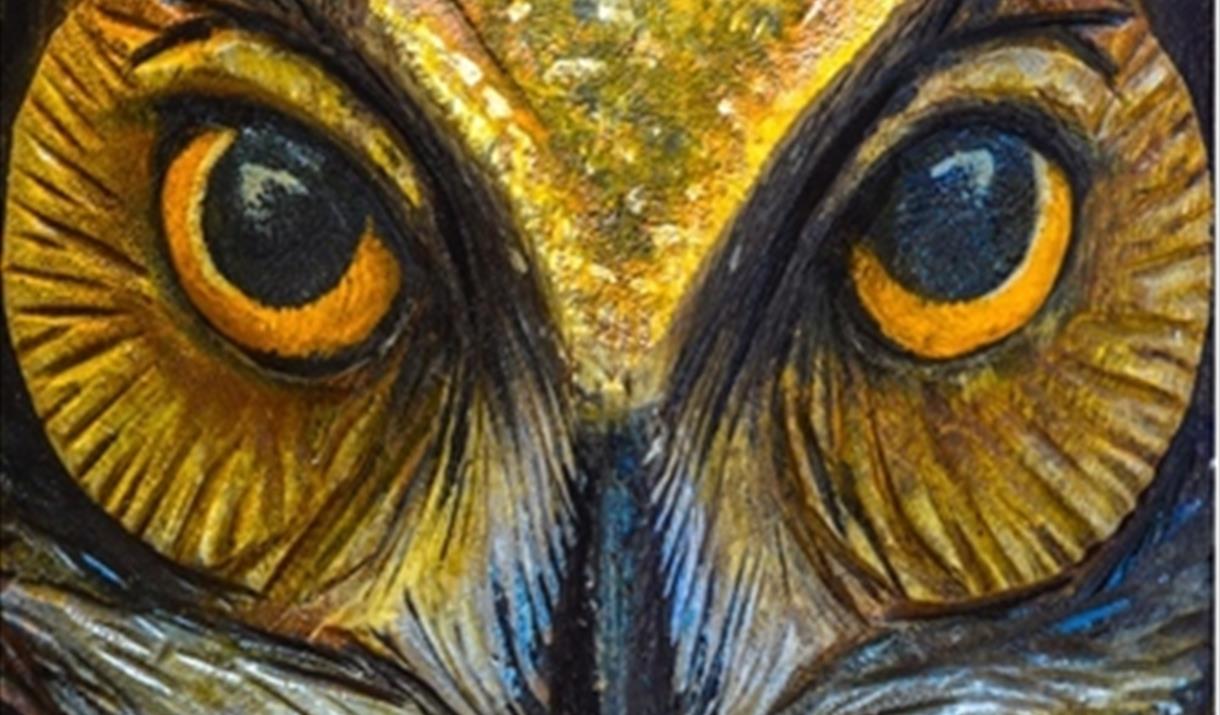 A close-up painting of an owl's eyes and beak