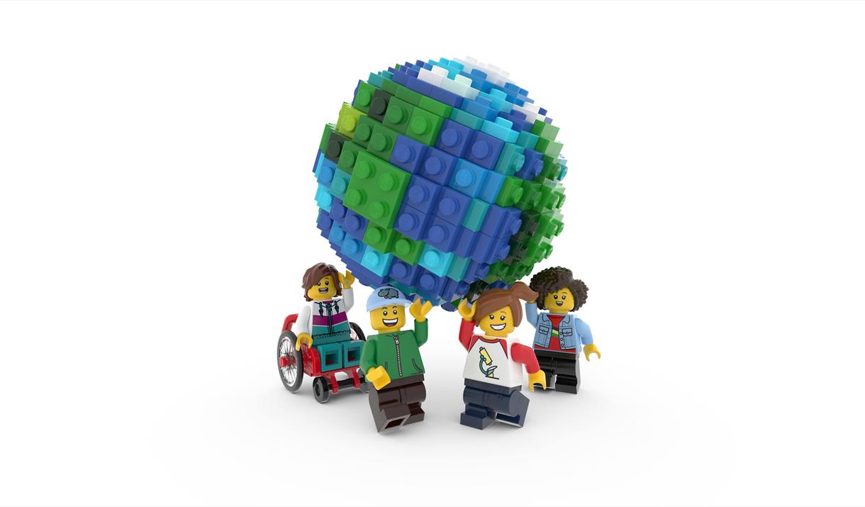 Four Lego people holding up a Lego globe.