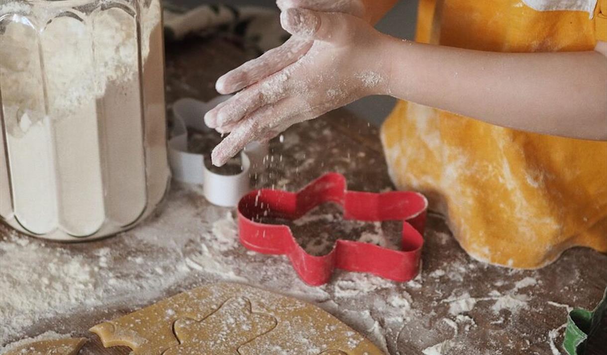 A young child making Christmas cookies.