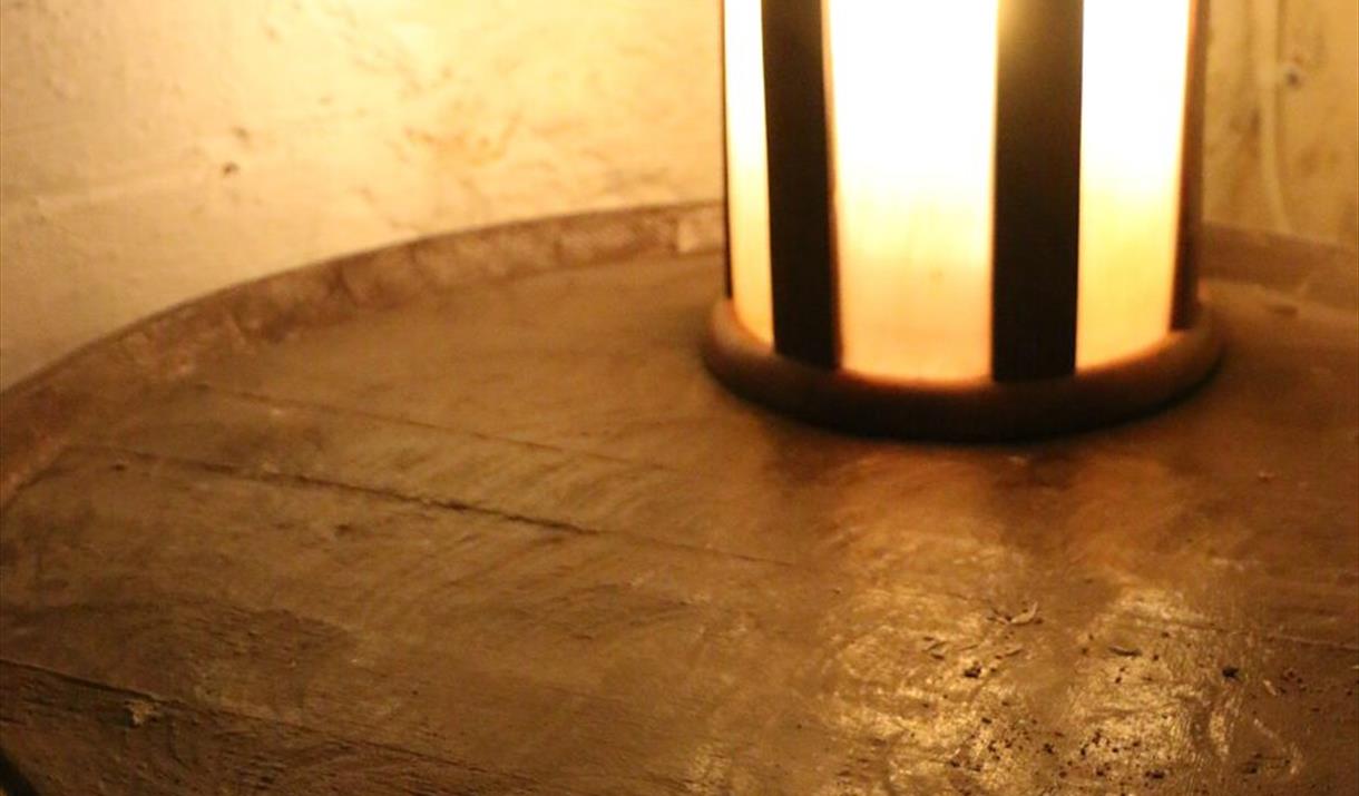 A photo of a old lantern lighting up a small circular table.