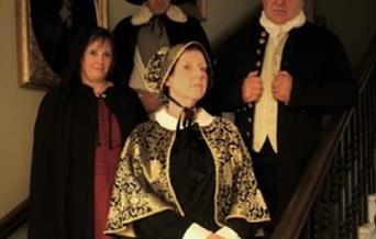 Costumed tour guides standing on Peterborough Museum staircase