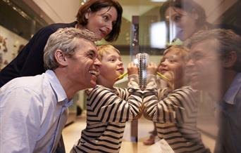 A picture of a family looking at an exhibit.