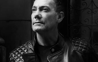 A black and white photo of Craig Revel Horwood
