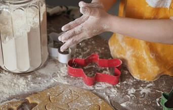 A young child making Christmas cookies.
