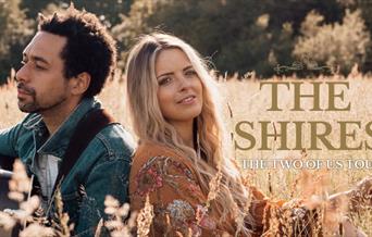 Image of the Shires sitting in a field. Text reads: The Shires, the Two of Us tour.
