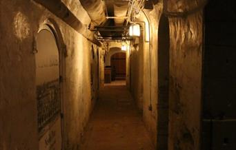 A photograph of a dimly lit corridor within the Museum's cellars.